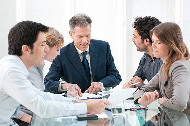 Mature businessman working and discussing with his colleagues at office.